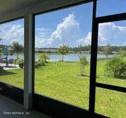 sunroom featuring a water view