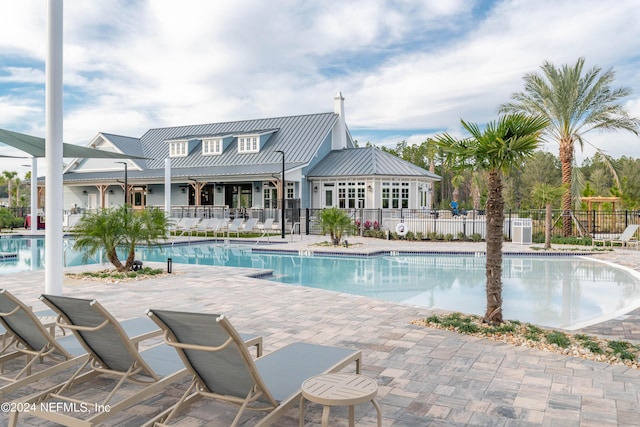 community pool featuring fence and a patio