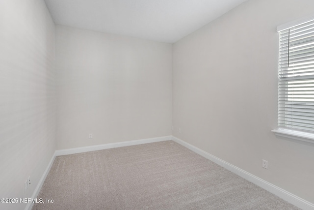 spare room with baseboards and carpet flooring