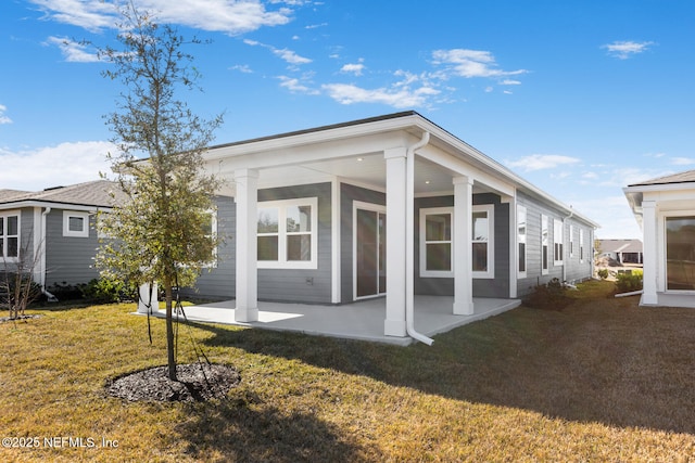 back of property with a yard and a patio