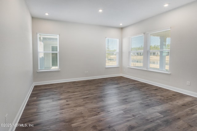 empty room featuring recessed lighting, dark wood-style flooring, and baseboards