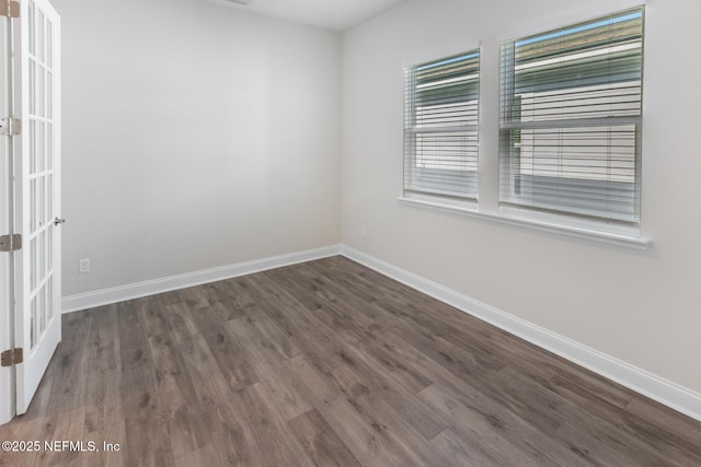 unfurnished room featuring dark wood-style floors, french doors, and baseboards