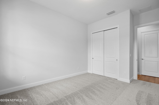 unfurnished bedroom with a closet and carpet floors