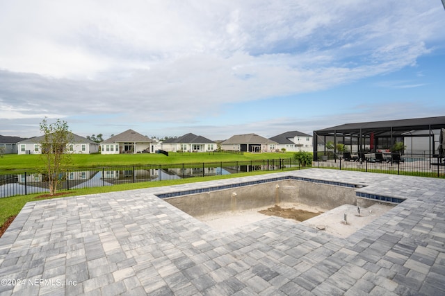 view of swimming pool featuring a patio, a water view, and a lawn