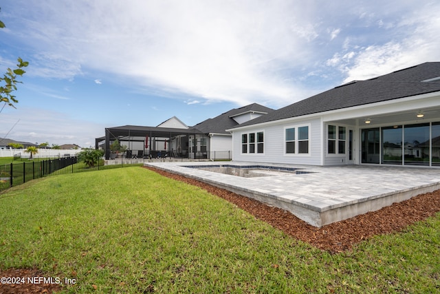 rear view of house with a patio, a yard, a fenced in pool, and glass enclosure