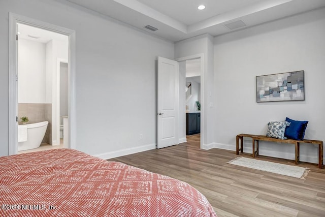 bedroom featuring connected bathroom and wood-type flooring