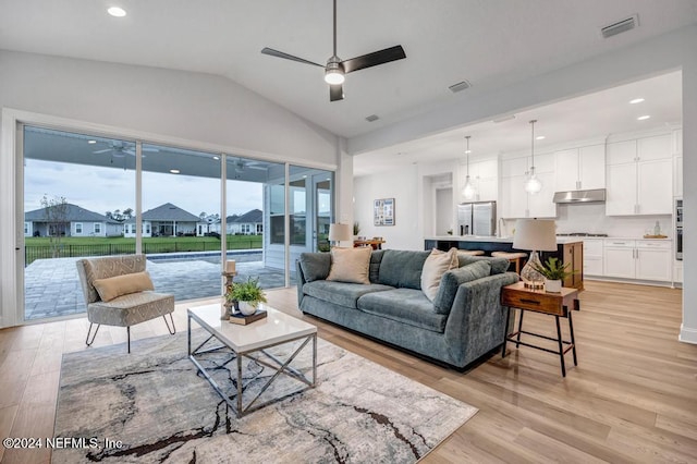 living room with vaulted ceiling, light hardwood / wood-style flooring, and ceiling fan