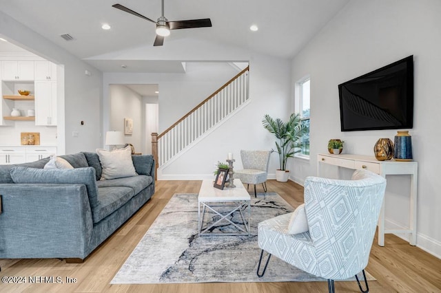 living room featuring light hardwood / wood-style flooring, vaulted ceiling, and ceiling fan