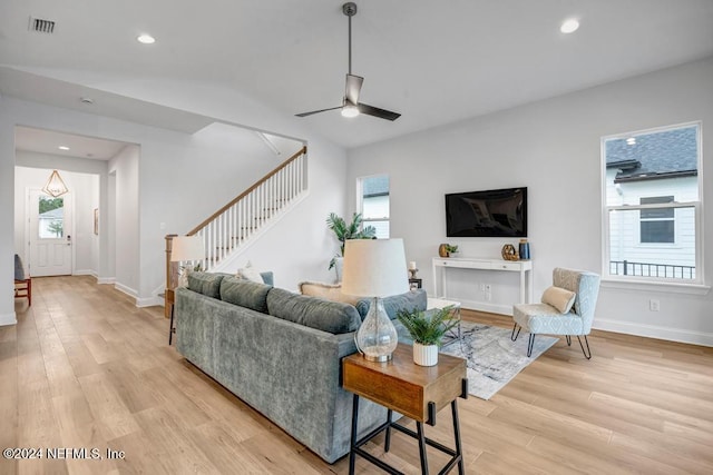 living room with a wealth of natural light, ceiling fan, and light wood-type flooring