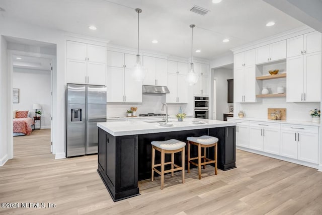 kitchen with white cabinets, light wood-type flooring, a kitchen island with sink, and appliances with stainless steel finishes