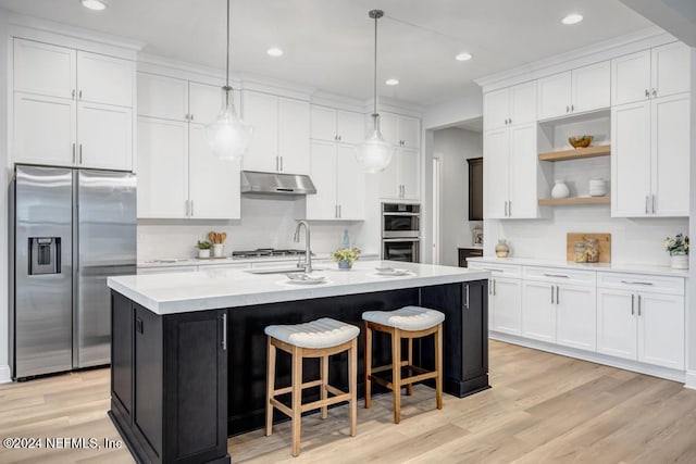 kitchen featuring a kitchen island with sink, white cabinets, and appliances with stainless steel finishes