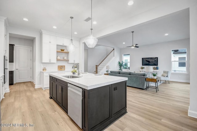 kitchen featuring stainless steel appliances, ceiling fan, sink, a center island with sink, and hanging light fixtures