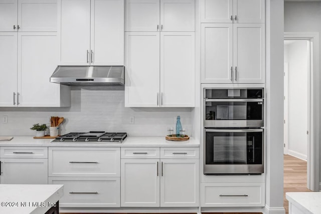 kitchen with hardwood / wood-style floors, stainless steel appliances, and white cabinetry