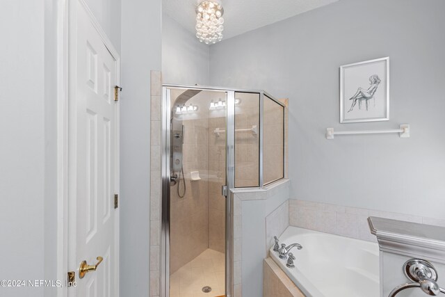 bathroom featuring a shower stall and a bath