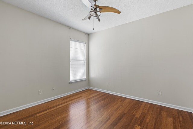 empty room featuring a ceiling fan, a textured ceiling, baseboards, and wood finished floors