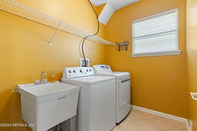 laundry room with light tile patterned floors, laundry area, a sink, baseboards, and washer and clothes dryer