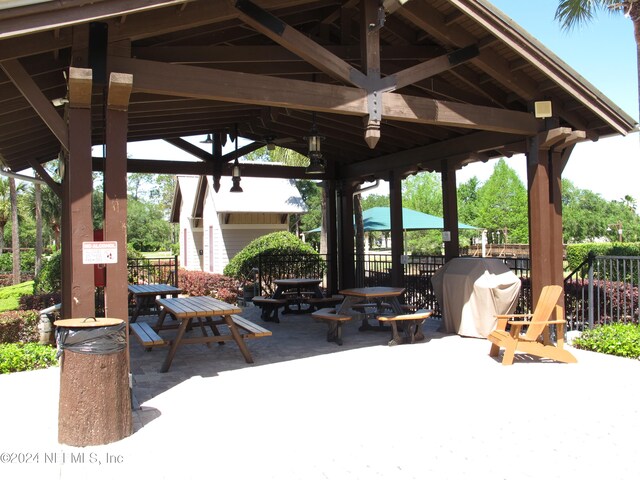 view of patio featuring a gazebo, outdoor dining space, and fence