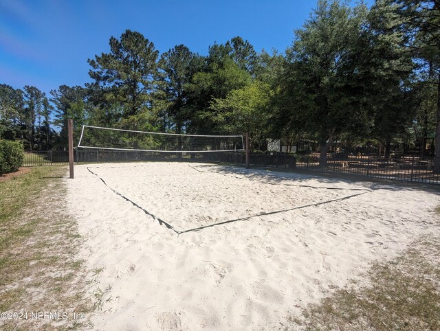 view of home's community featuring volleyball court and fence