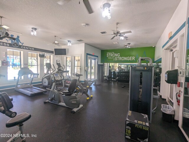 exercise room with a ceiling fan, visible vents, and a textured ceiling