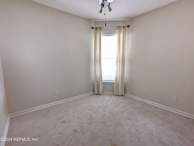 empty room featuring carpet flooring, a textured ceiling, and baseboards