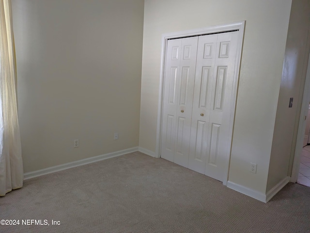 unfurnished bedroom with carpet floors, baseboards, and a closet