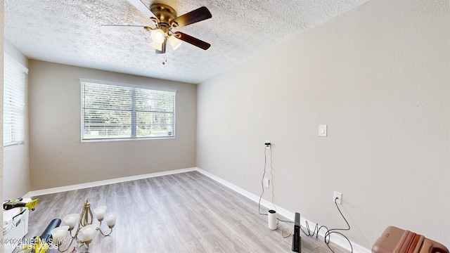 unfurnished room featuring light hardwood / wood-style flooring, ceiling fan, and a textured ceiling