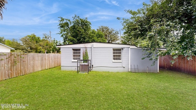 exterior space with central AC and a yard