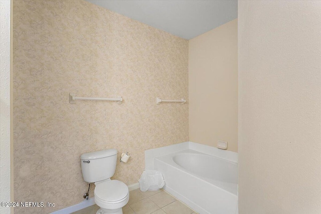 bathroom with toilet, tile flooring, and a tub