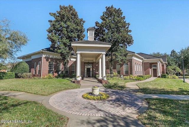 greek revival house featuring a front lawn