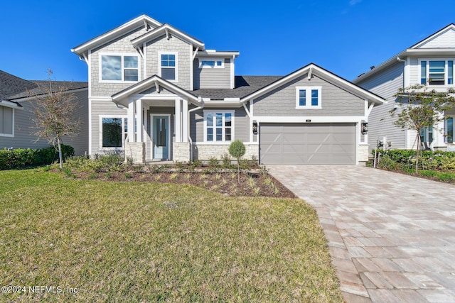 craftsman inspired home with a garage and a front yard