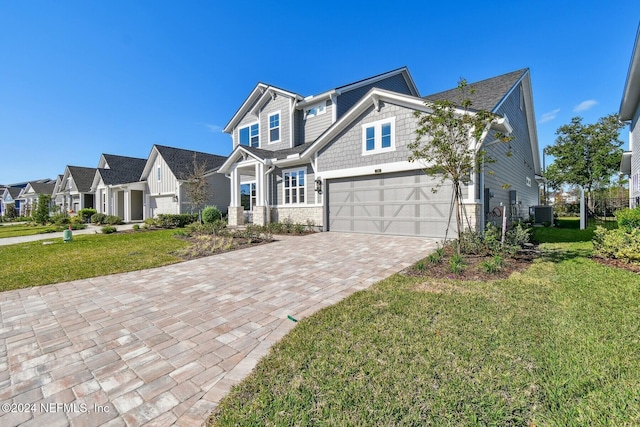 view of front of property with a garage, central AC unit, and a front lawn