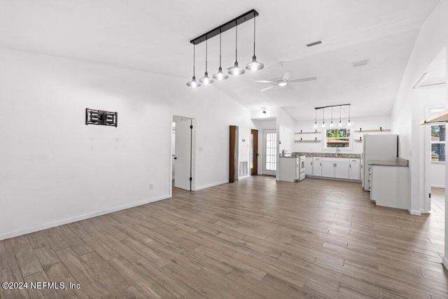 unfurnished living room featuring hardwood / wood-style flooring, rail lighting, and ceiling fan