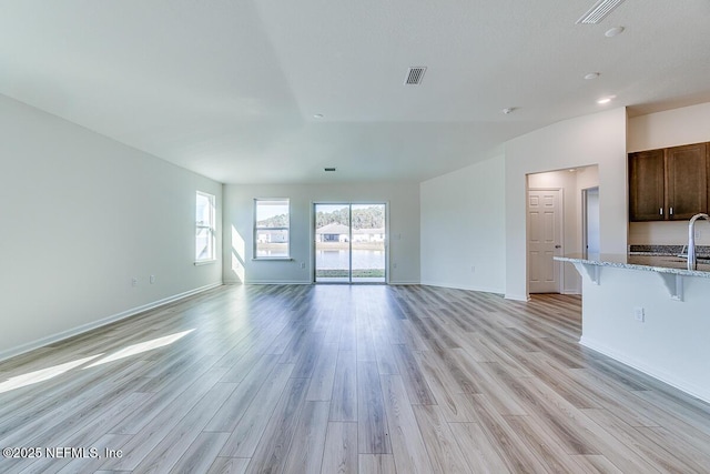 unfurnished living room with light wood-type flooring and sink