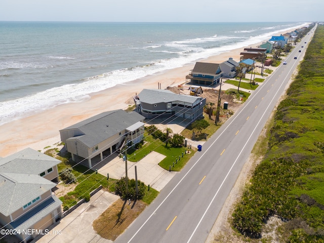 drone / aerial view featuring a beach view and a water view