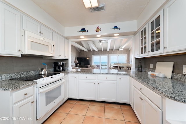 kitchen with white appliances, light tile flooring, backsplash, kitchen peninsula, and beam ceiling