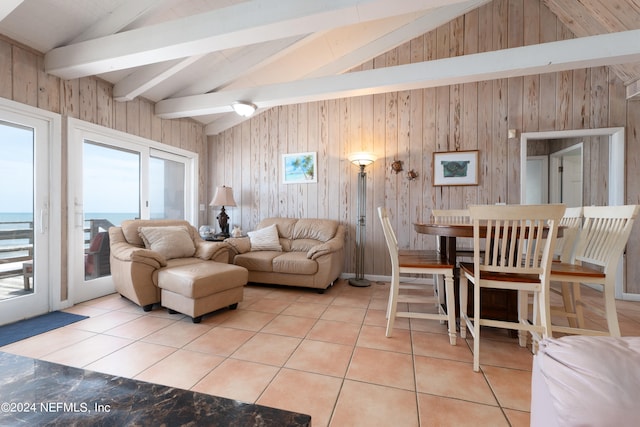 living room with a water view, vaulted ceiling with beams, and wooden walls