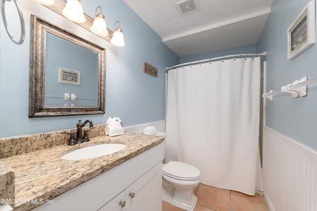 bathroom with tile flooring, oversized vanity, and toilet