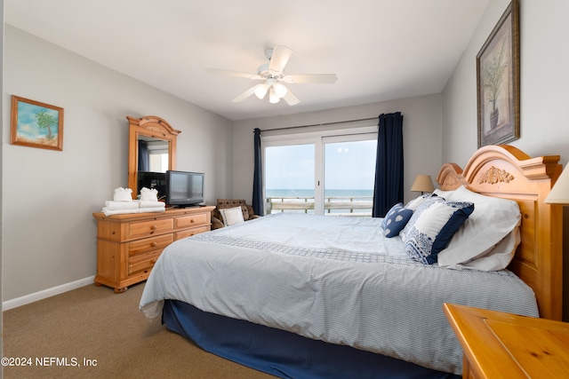 carpeted bedroom with ceiling fan and a water view