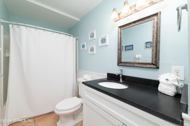 bathroom with tile floors, vanity, and toilet