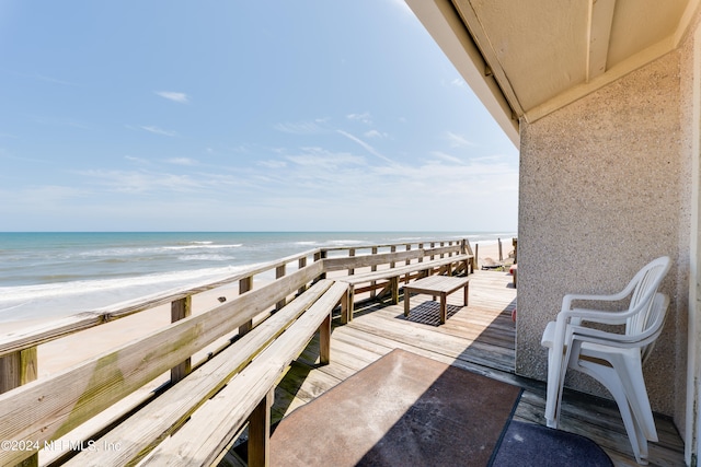 balcony featuring a beach view and a water view