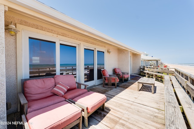 wooden terrace with outdoor lounge area and a water view