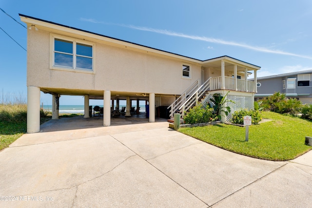 raised beach house featuring a carport and a front yard