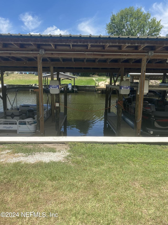 view of dock with a water view and a yard