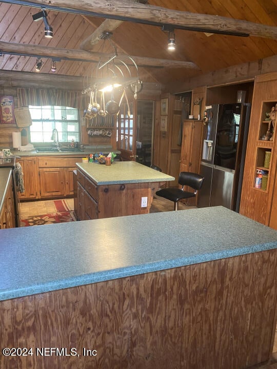 kitchen with rail lighting, refrigerator, wood ceiling, electric stove, and a center island