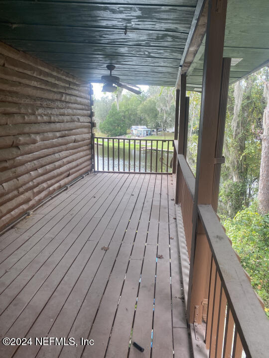 wooden terrace featuring a water view and ceiling fan