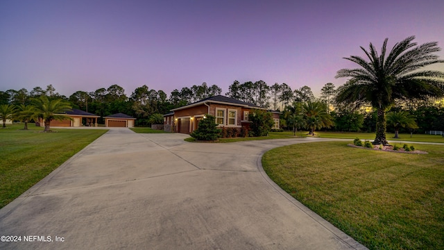 ranch-style home featuring a lawn and a garage