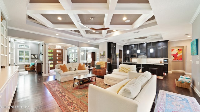 living room featuring ceiling fan, dark hardwood / wood-style flooring, coffered ceiling, and crown molding