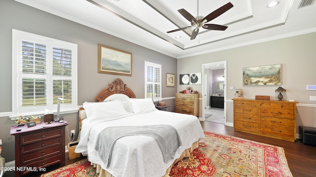 bedroom featuring connected bathroom, multiple windows, ceiling fan, and dark hardwood / wood-style floors