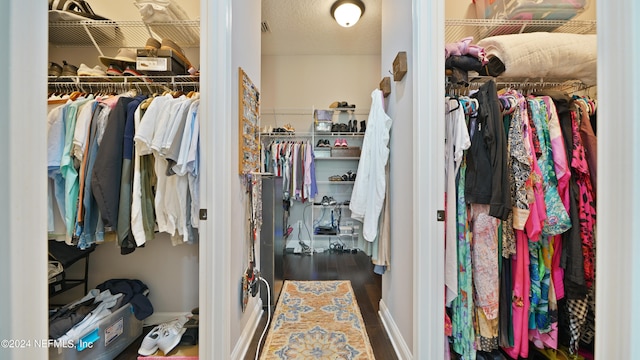 walk in closet with dark hardwood / wood-style flooring