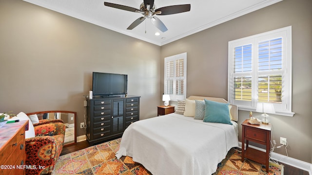 bedroom with ornamental molding, ceiling fan, and dark wood-type flooring